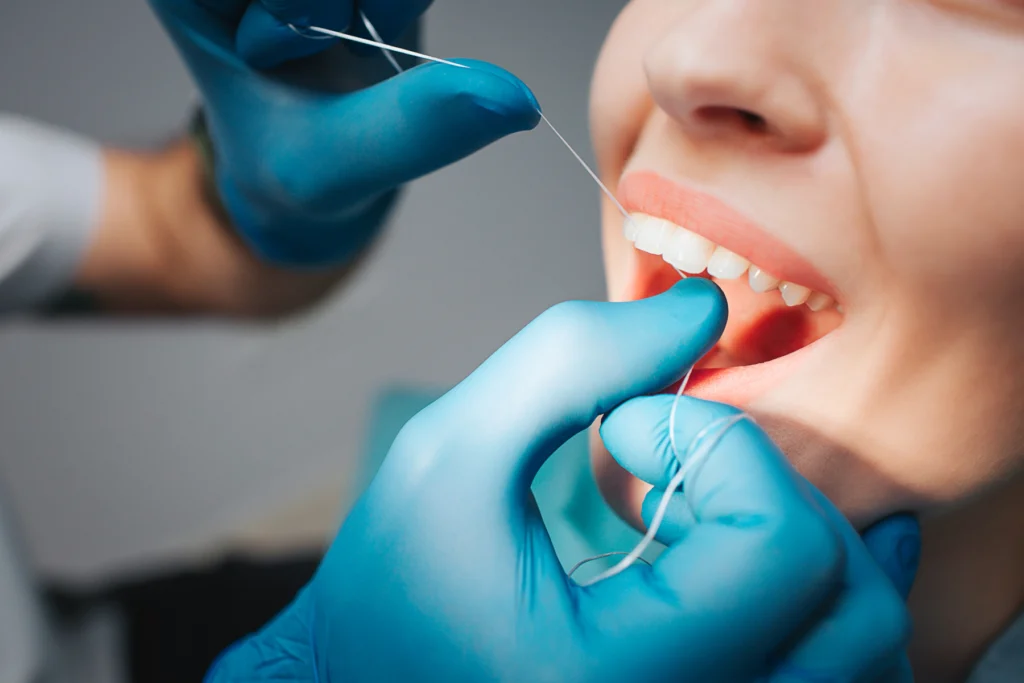 hygiene bucco dentaire dentiste Soin dentaire réalisé avec un instrument, patiente souriante